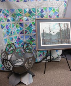 A handmade, queen-size quilt will be raffled at the 9th Annual Chili Cook Off. A St. Louis Cardinals fire pit and a Duck Unlimited water color are two of the live auction items at the cook off.
