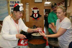 Carol Honeywell serves up chili from “Happy Feet” a cook off team sponsored by Raymondville United Methodist Church.