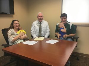 Dr. Jason and Dr. Teresa Loden have signed contracts to work full-time at TCMH. Teresa Loden (far left) is a pediatrician, and Jason Loden (far right) is a general surgeon. They are shown here with Wes Murray, CEO at TCMH. The couple is holding their daughters—Gabriella, a newborn, and Elliana, age 2. Both doctors will join the hospital in 2018.