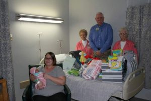 Sarah Dillin, seated, holds Hadley Rebecca Dillin, the first baby born at Texas County Memorial Hospital in 2017. Presenting gifts to the Dillin family were (standing left to right) Roma Hollenbeck, TCMH Auxiliary; Wes Murray, TCMH CEO, and Julia Bryant, TCMH Auxiliary.
